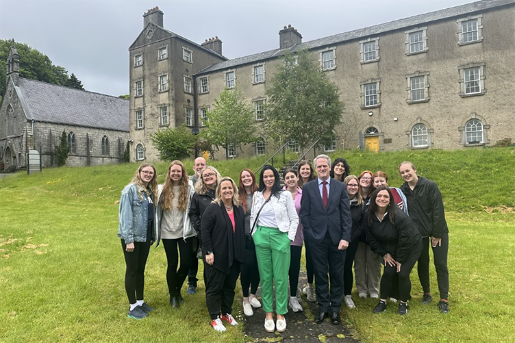 group of students stand together outside an historic building in Ireland